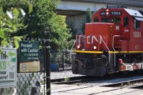CN 1004 leads a freight over the crossing at the entrance to Ping Tom Park