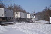 Trailers kicking up snow on the curve